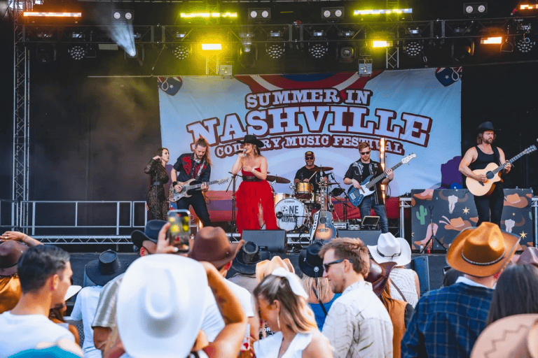 Live band performing at Nashville country music festival with crowd watching.